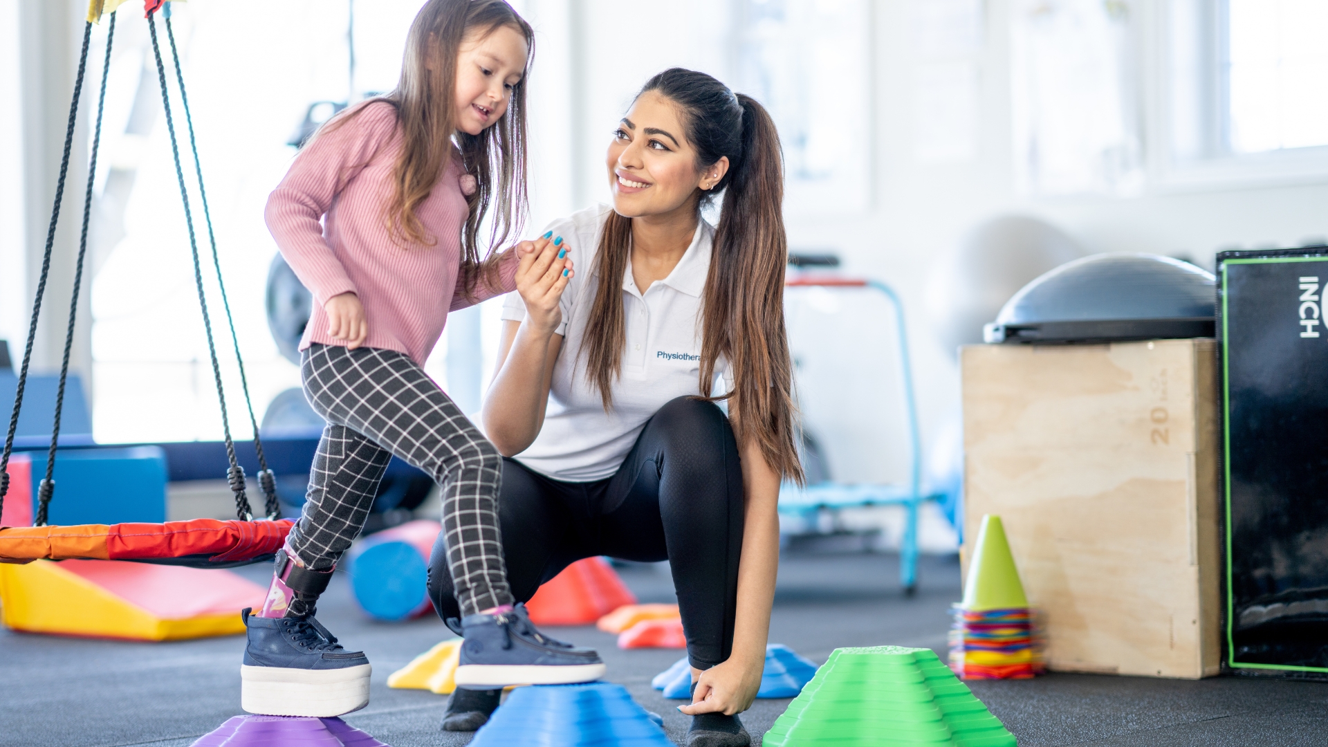 Child building fine motor and independence skills with a pediatric occupational therapist